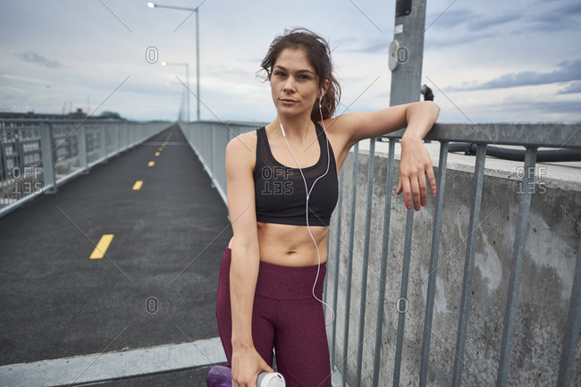 Confident woman drinking water while training on bridge, Montreal, Quebec, Canada