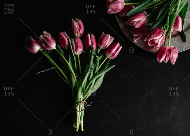 Bunch of tulips made into bouquet with second bunch laid out on platter