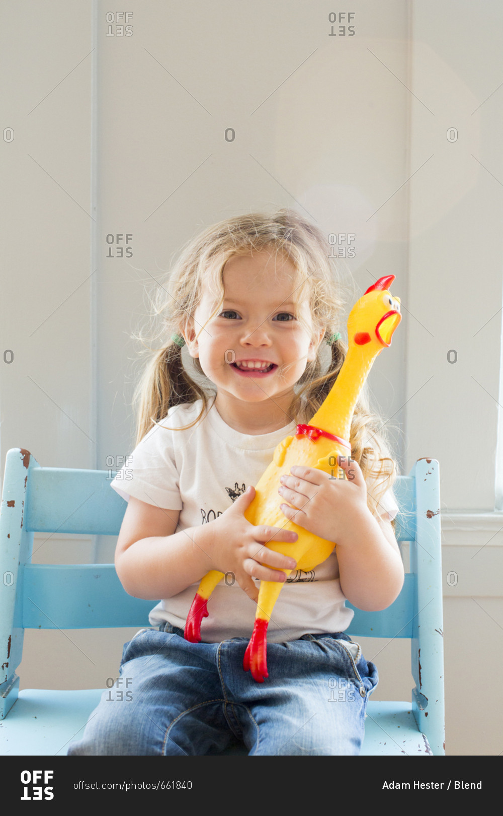 Smiling Caucasian girl holding rubber chicken