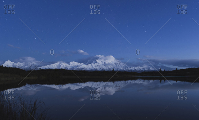 Reflection of scenic view of mountain in pond