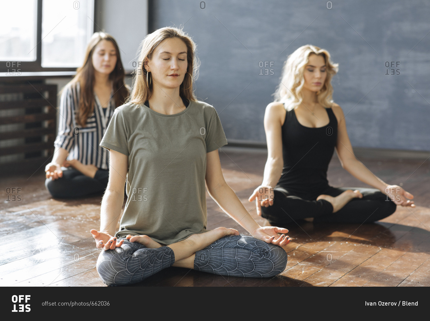 Caucasian women meditating in yoga class stock photo OFFSET