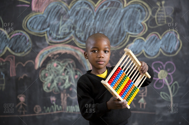 A boy holding an abacus