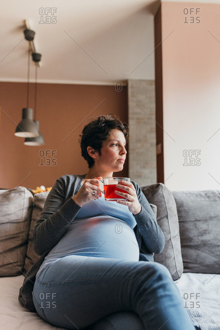 Portrait of 9 month pregnant woman drinking tea