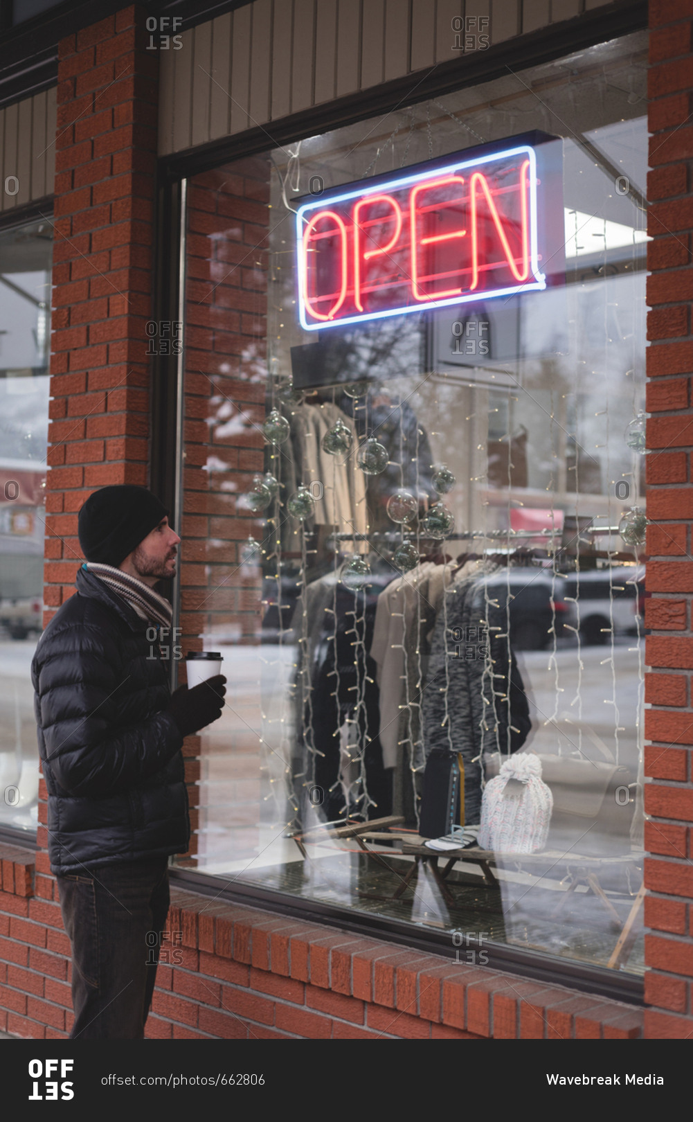 Young man looking at window display of shop