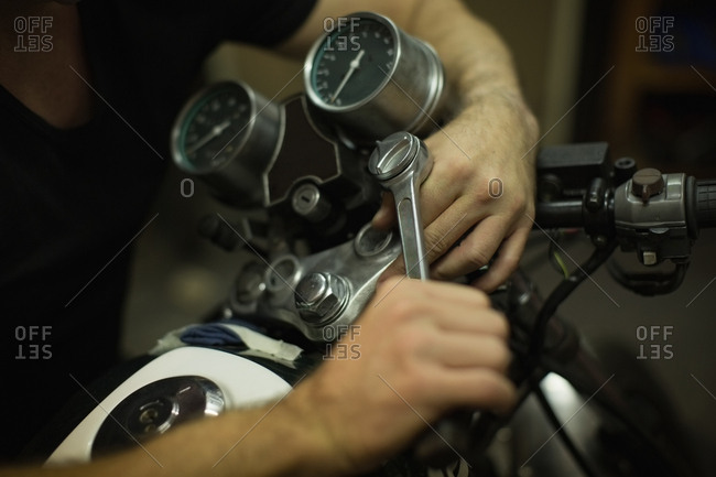 Mechanic tightening motorbike bike handle in garage