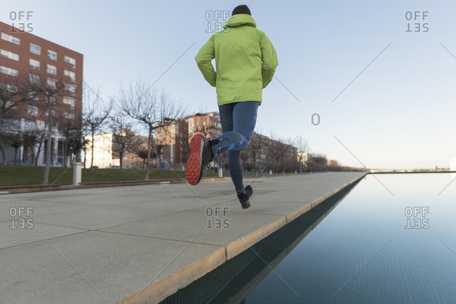 Man running in city park in sports attire