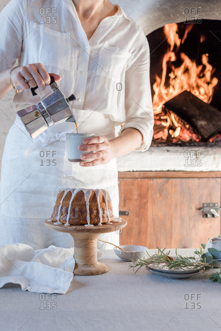 Person pouring coffee next to cake