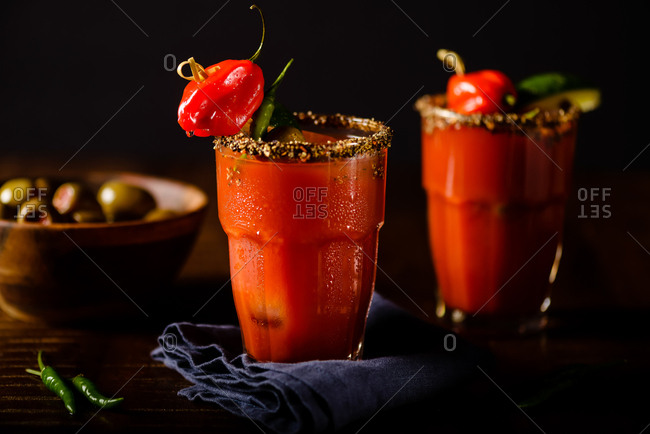 Very spicy Bloody Mary cocktails with hot peppers and olives