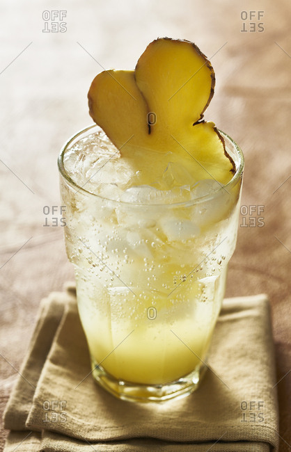 Glass of sparkling lemon ginger soda with ginger garnish
