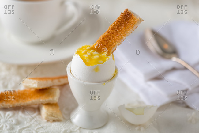 Soft boiled egg in egg cup with toast