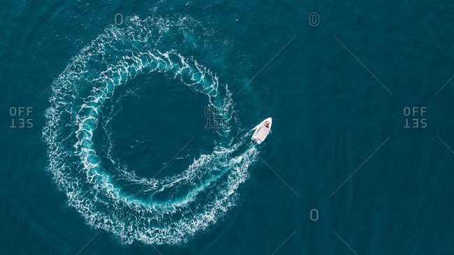 Aerial view of a boat driving in circle in the sea