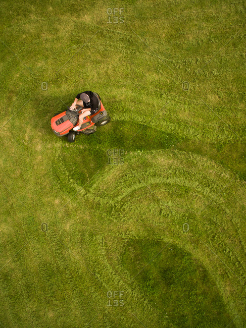 Aerial view of a man mowing the lawn creating shapes