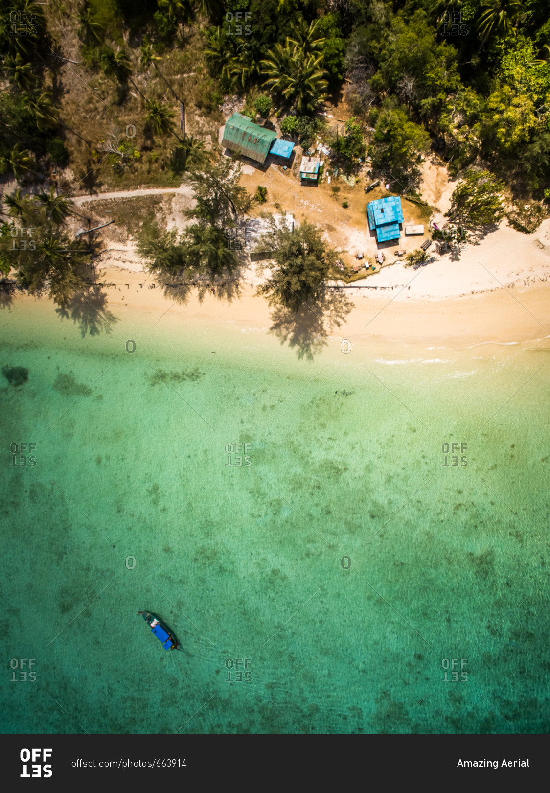 Aerial view of a boat moored in the paradisiacal sea close to small houses on the beach in Chao Mai National Park in Thailand
