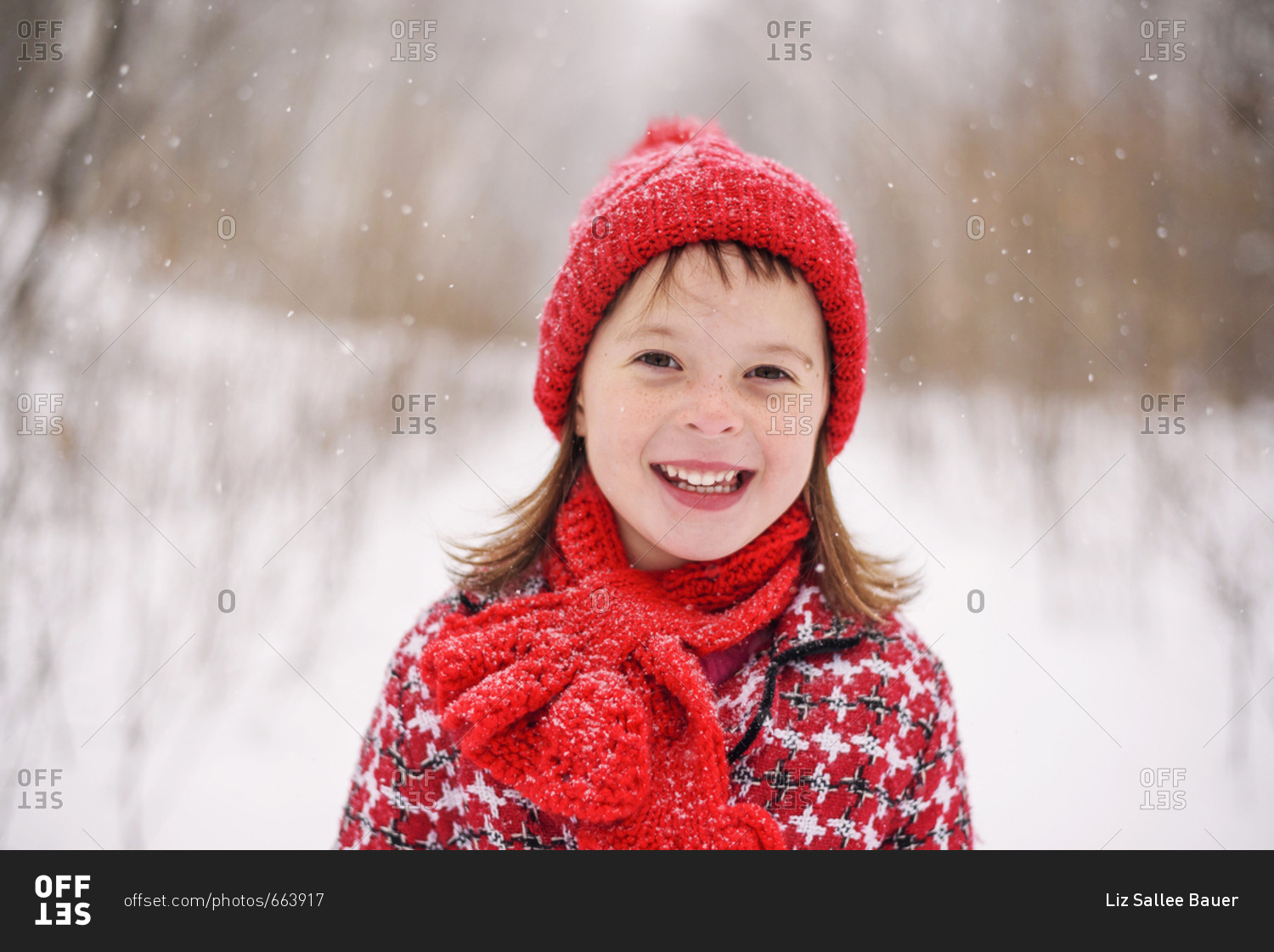 Portrait of young girl smiling in the snow stock photo - OFFSET