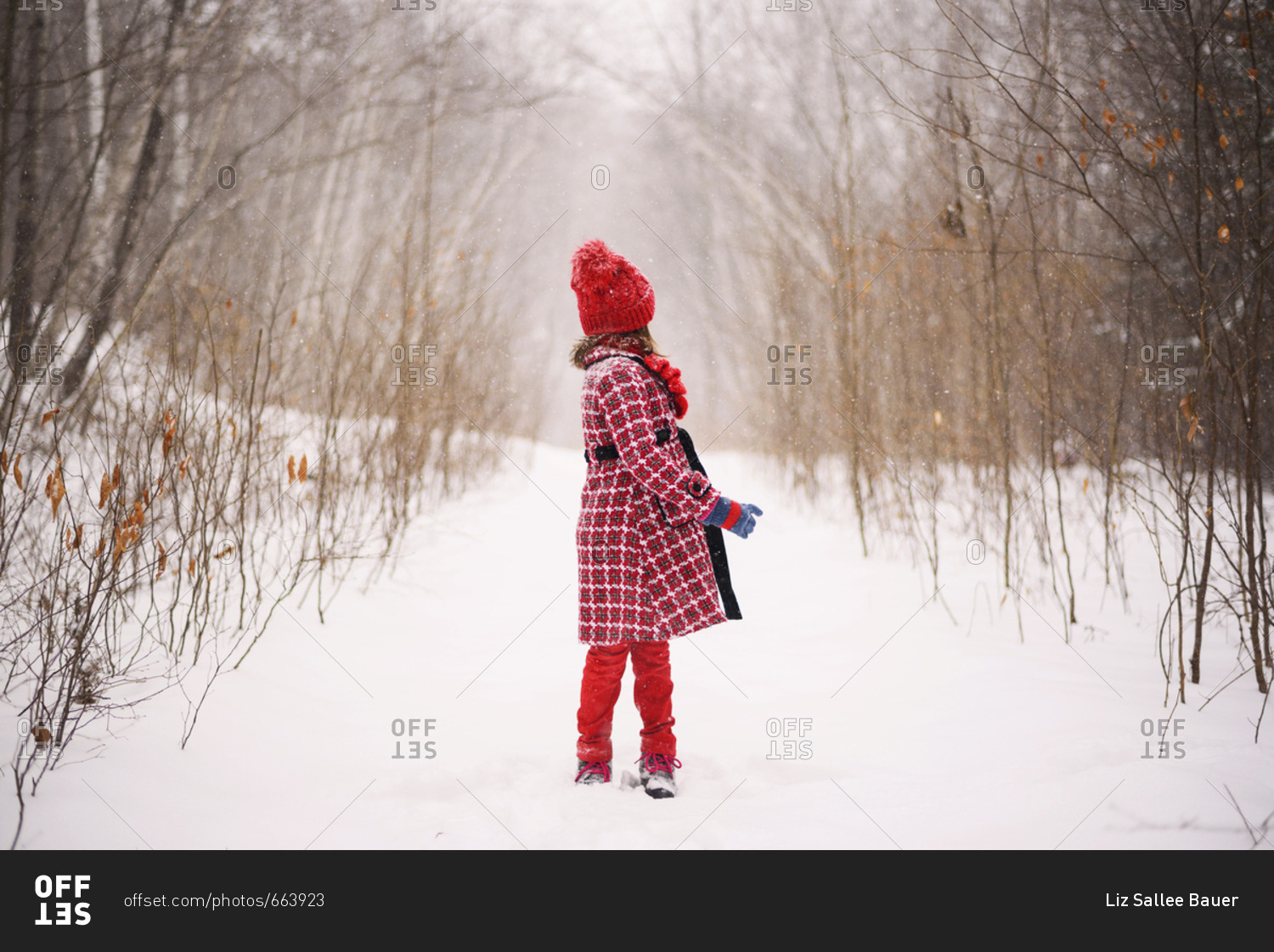 Full length view of young girl turning away as snow falls