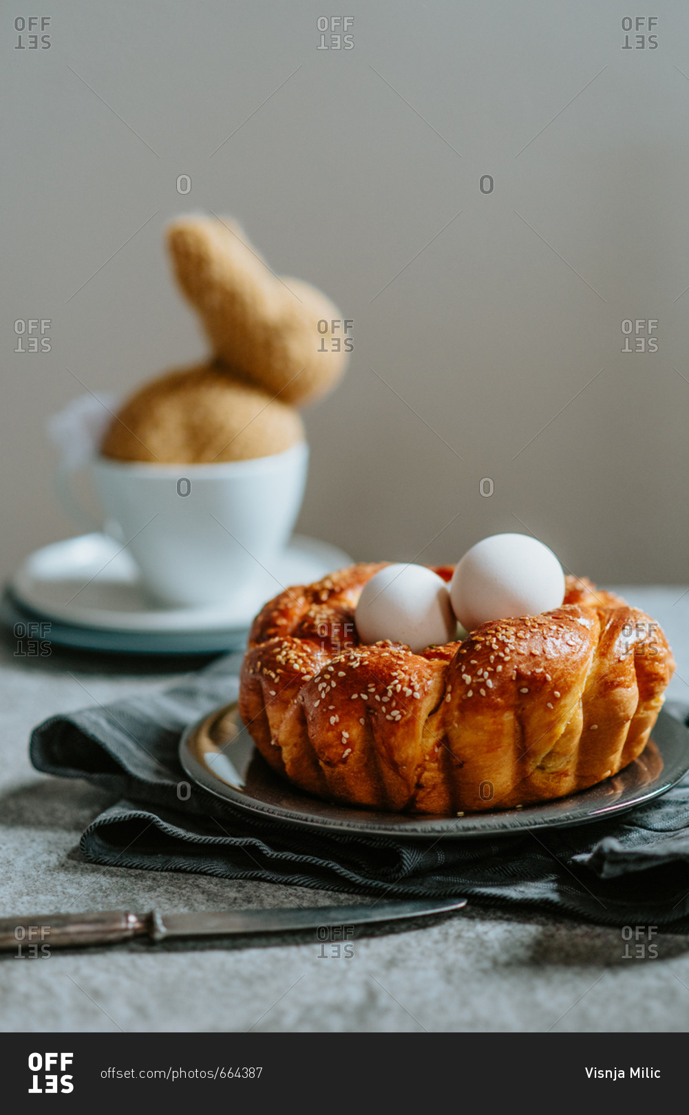 Easter braided nest like pastry with eggs inside and knitted bunny in the background