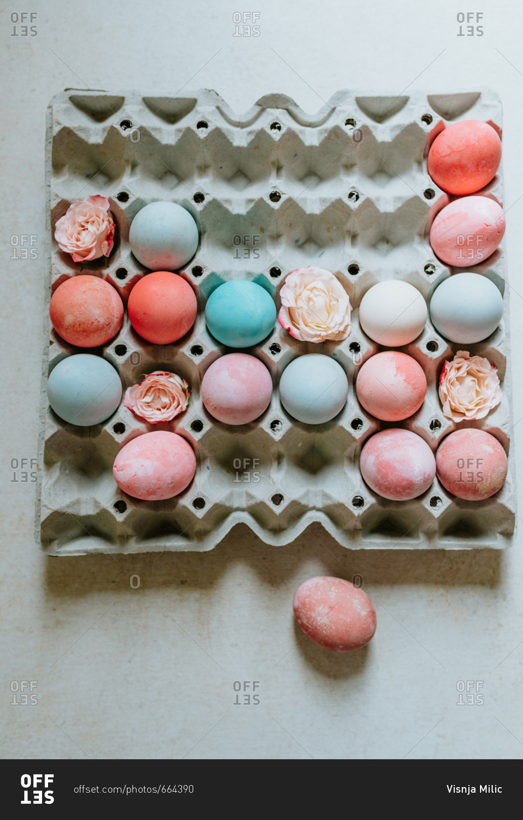 Flatlay shot of pastel pink and turquoise Easter eggs in carton