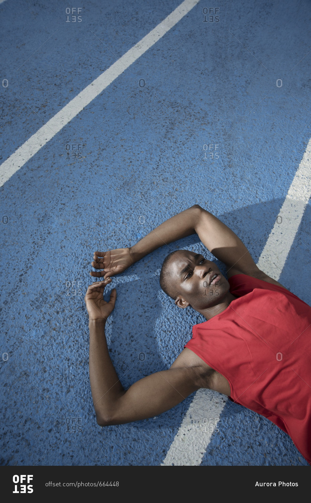 Runner lying while resting on sports track, Barcelona, Catalonia, Spain