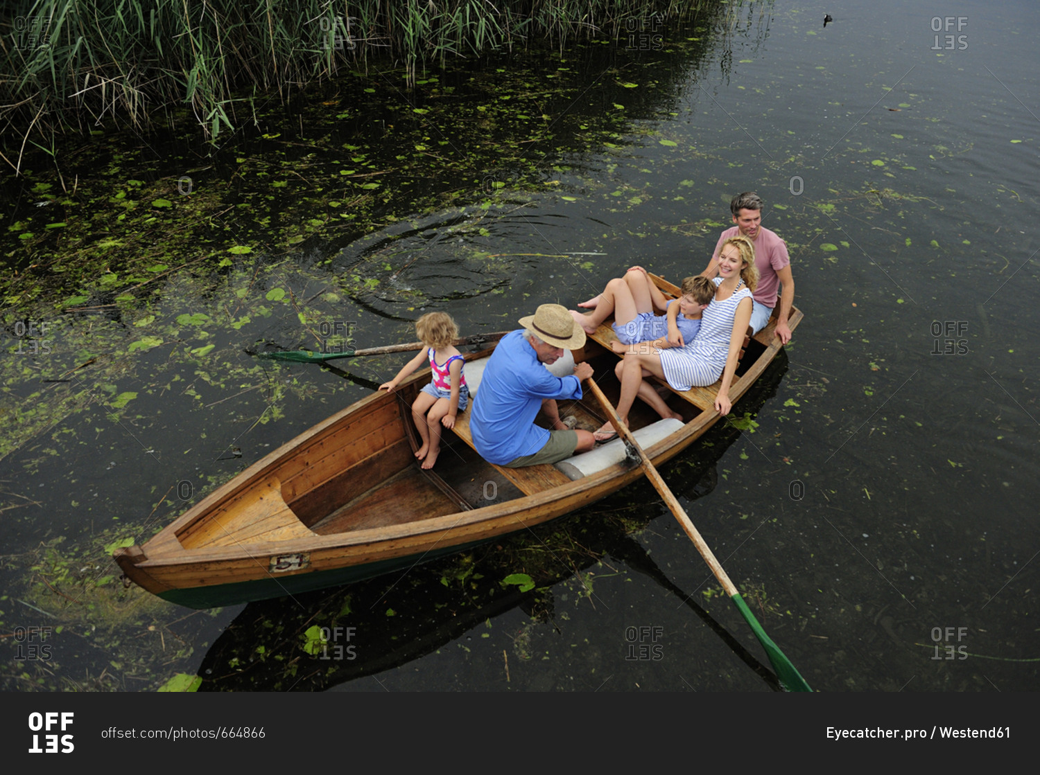 family-in-rowing-boat-on-lake-stock-photo-offset