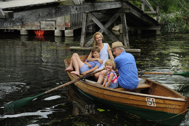 Happy family in rowing boat on lake