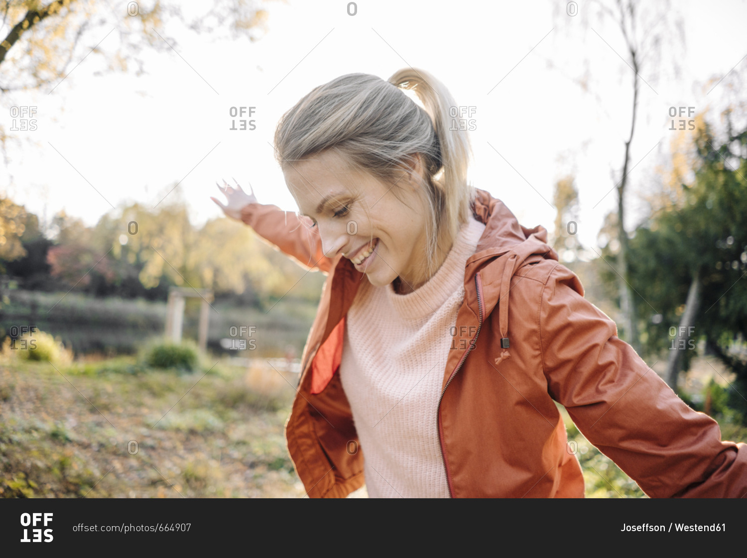 Portrait of happy young woman balancing in autumnal park