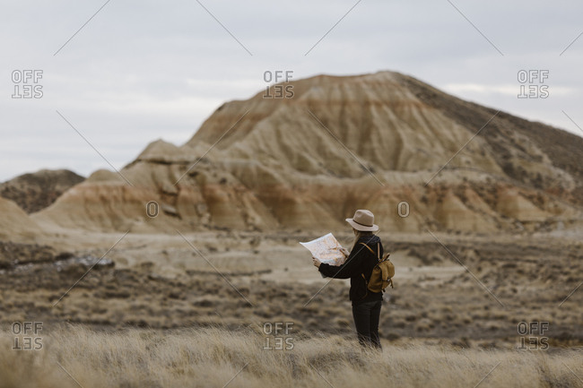 Woman with map standing in barren landscape