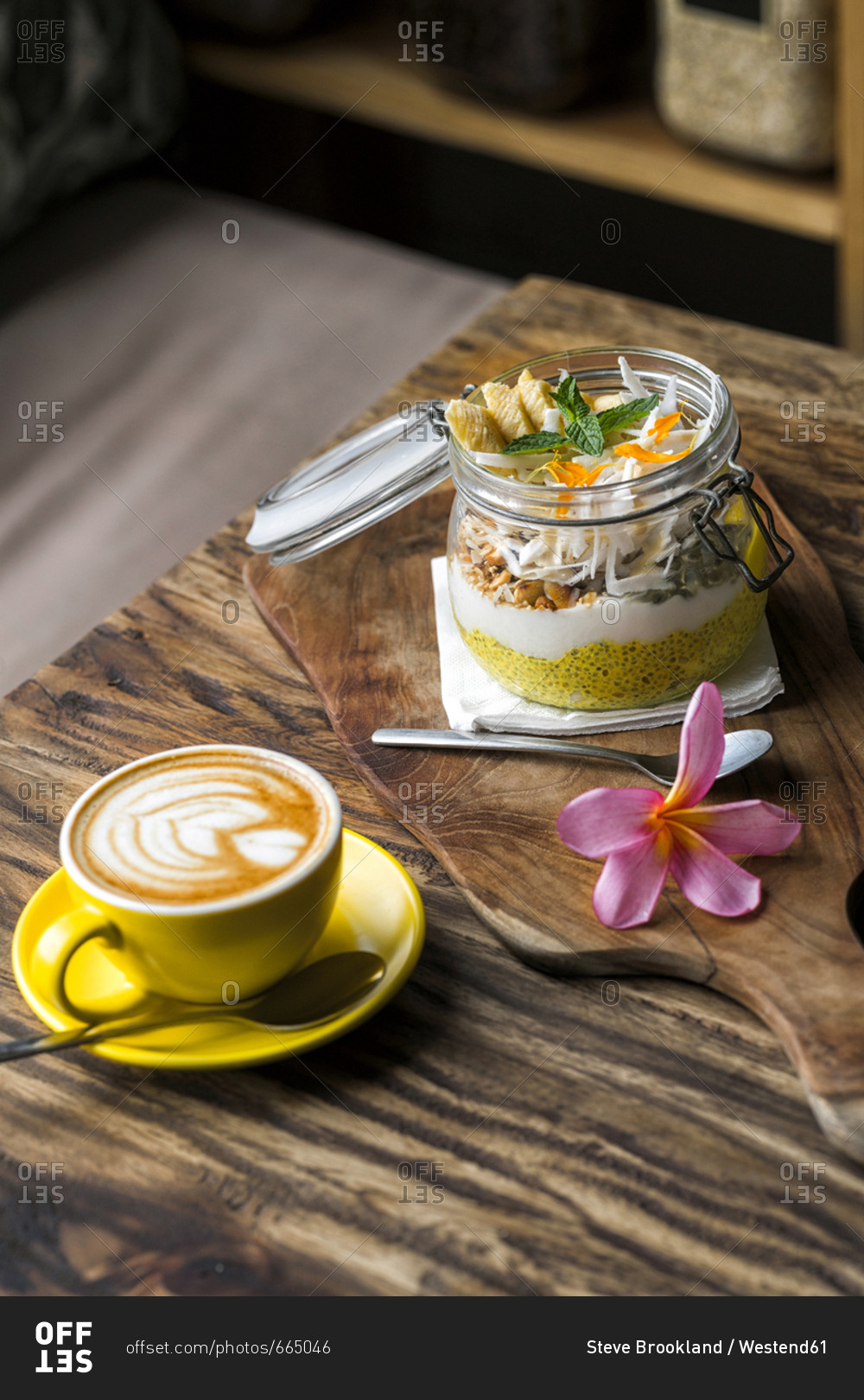 Exotic muesli with flower and coffee cup on a wooden table