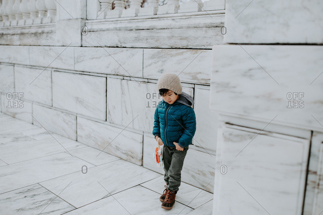 Little boy with toy camera caught at solemn moment