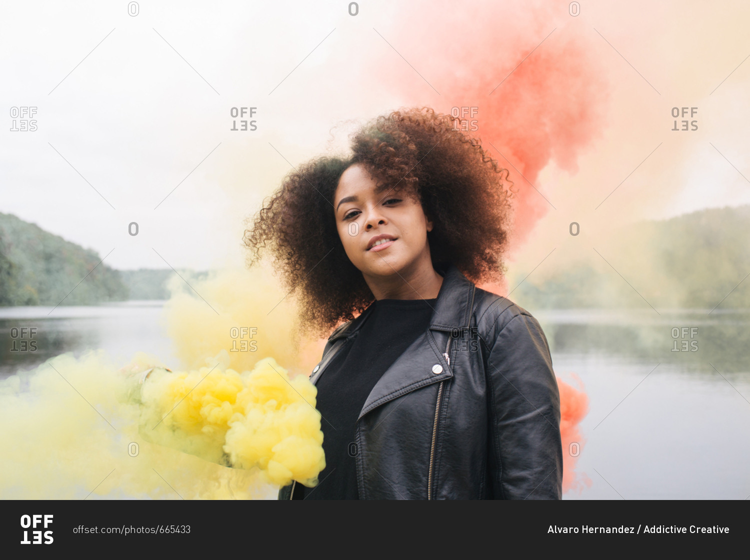Young woman with colored smoke bombs