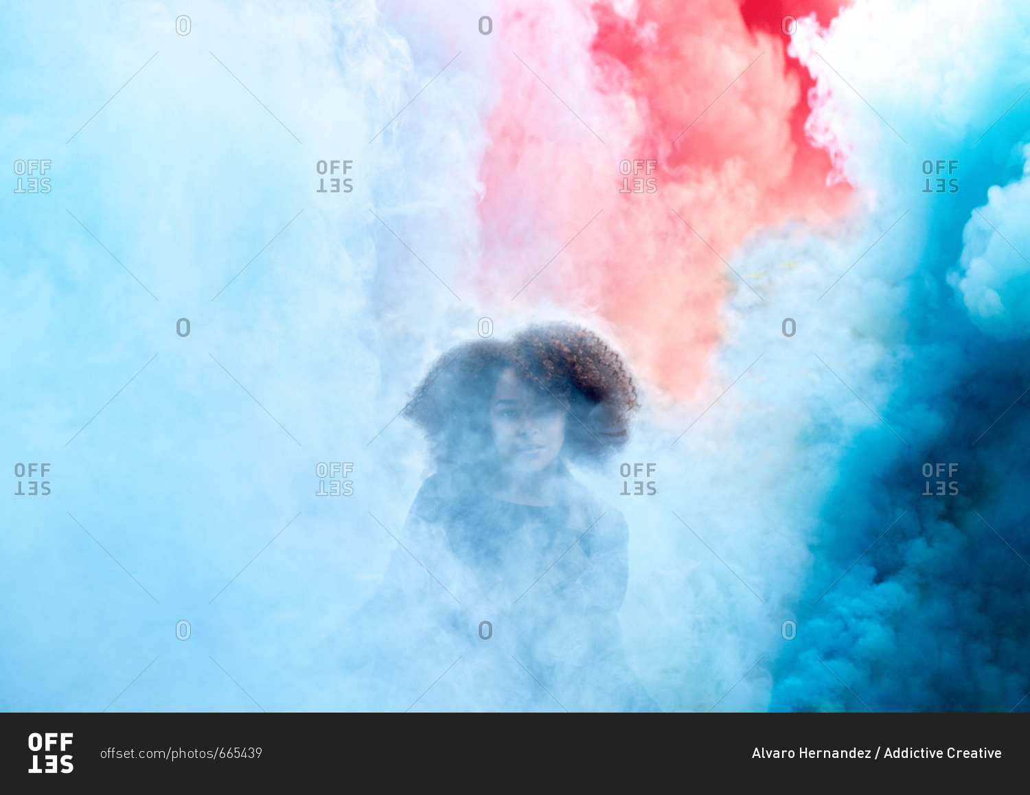 Young woman with colored smoke bombs
