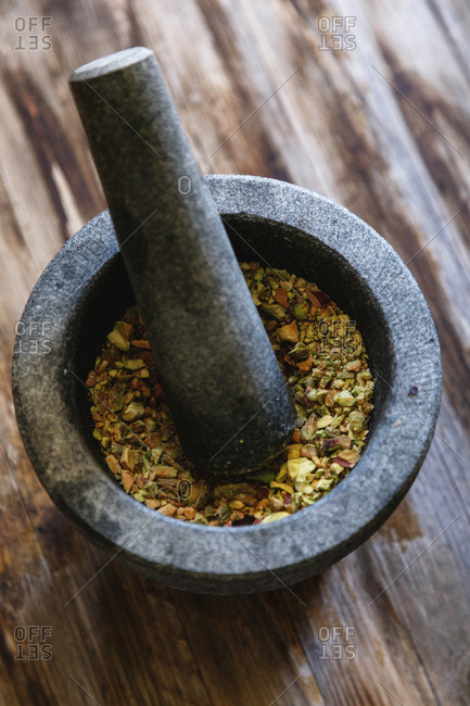 Mortar and pestle filled with crushed pistachios