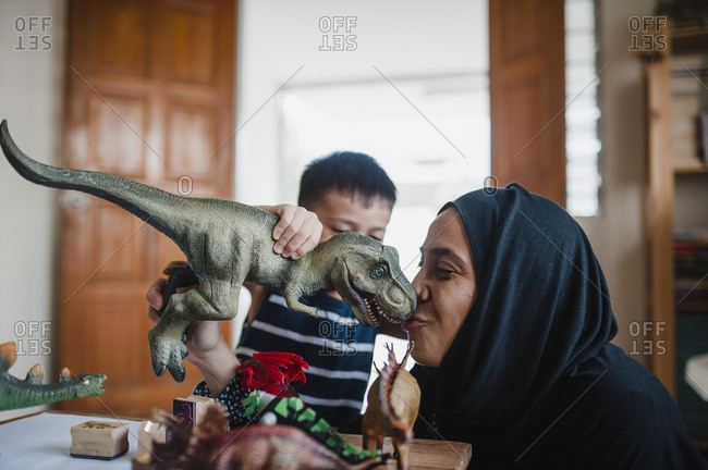 Mother and son playing with dinosaurs together