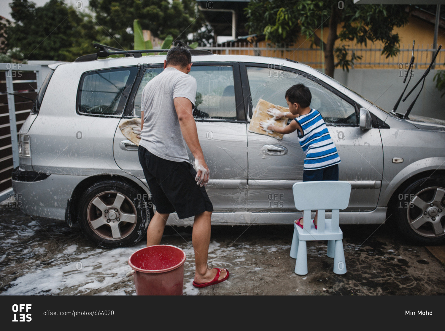 Father and son washing car together