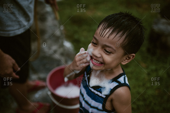 Father and son playing in soapy water