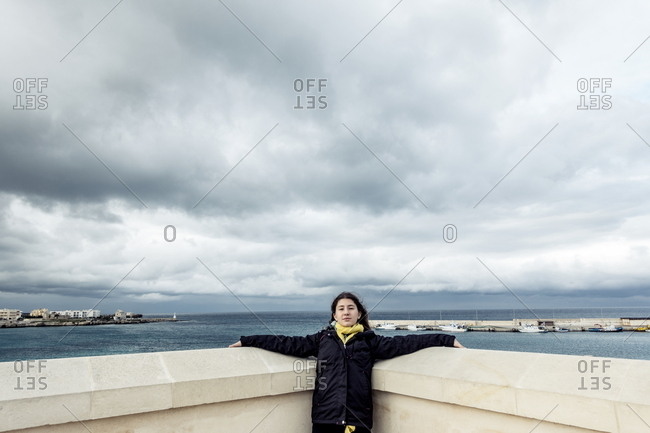 Girl traveler posing in corner wall at oceanside attraction