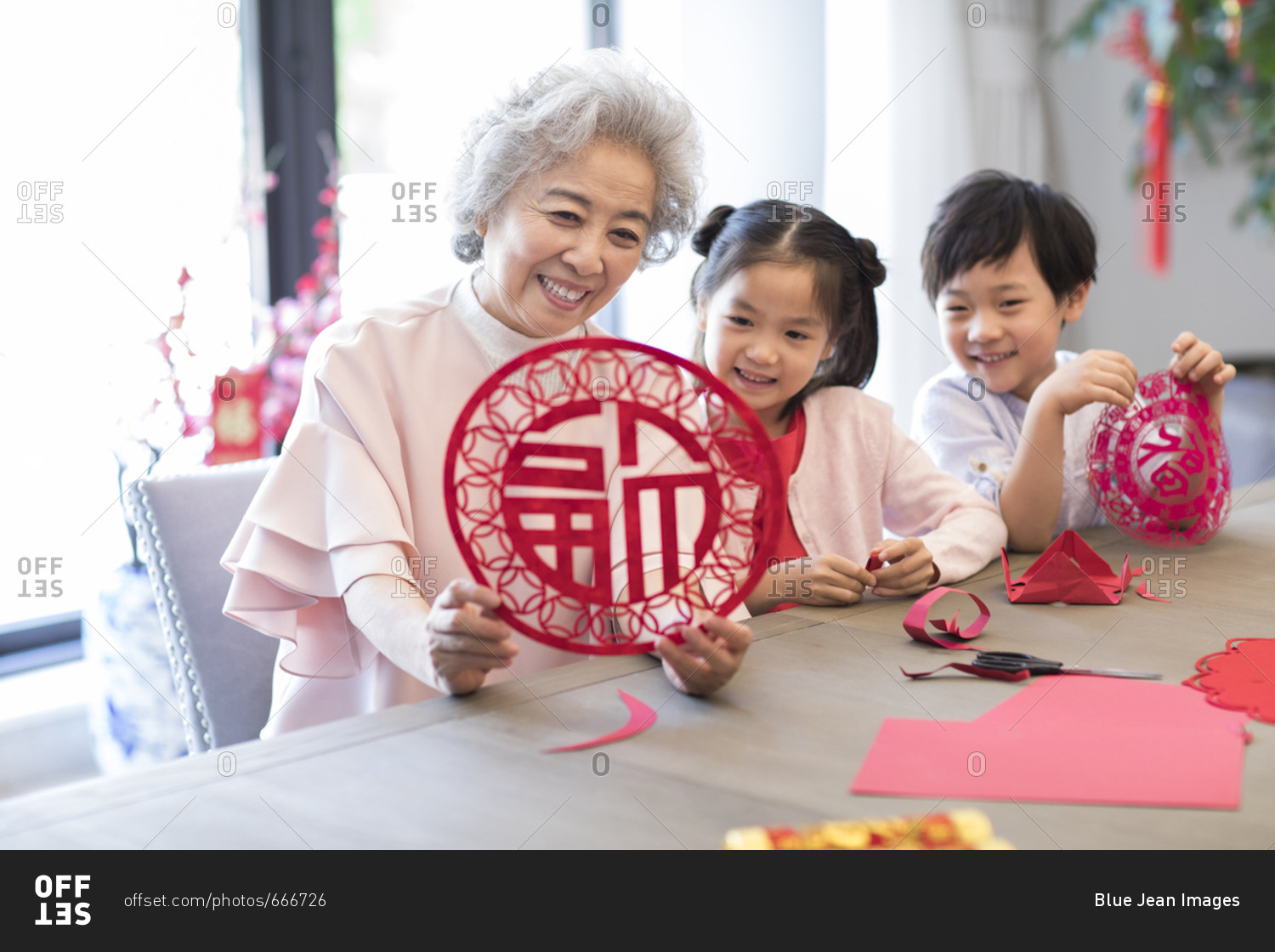 Grandchildren and grandmother with Chinese New Year paper-cut