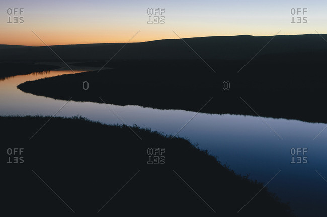 The open spaces of marshland and water channels, flat calm water at dusk