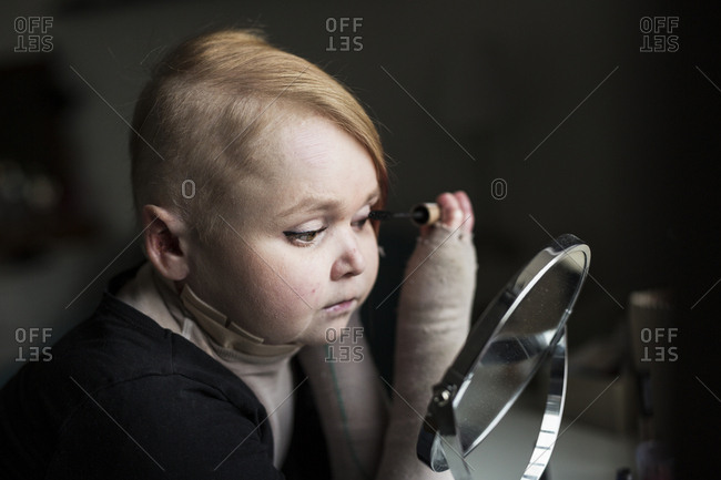 Disabled young woman doing make-up