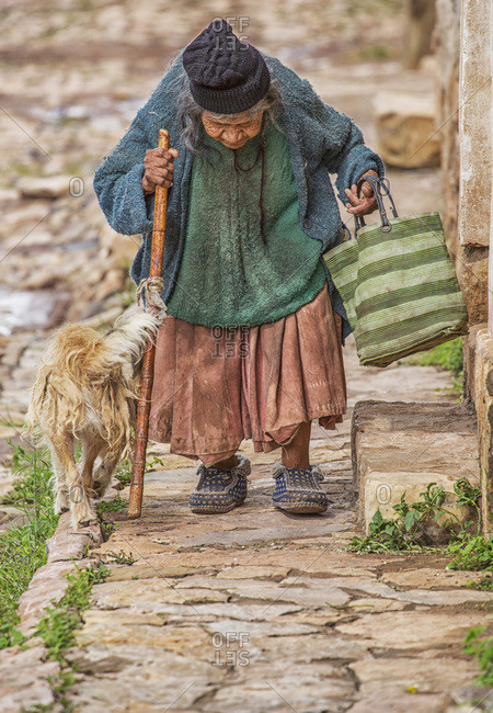 January 16, 2015: An Elderly Woman Walks Down The Cobblestone Sidewalk; Toro Toro, Bolivia