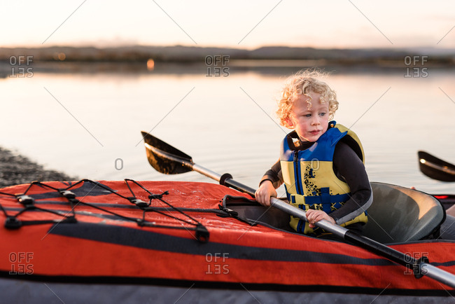 Little boy waiting in front seat of Kayak sunset