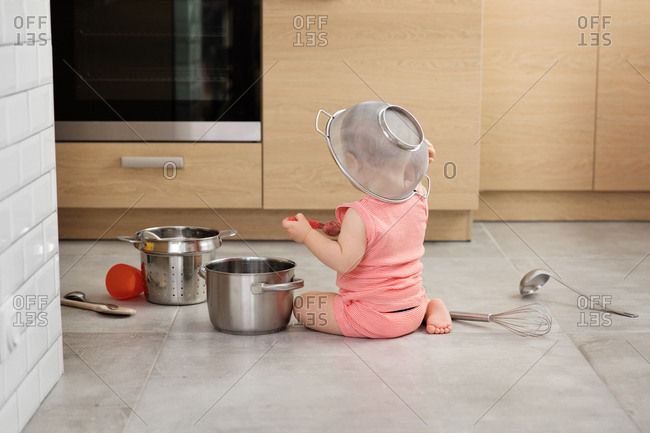 Baby sitting on floor with kitchenware