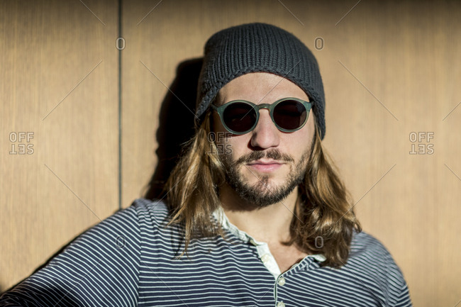 Portrait of bearded man with long hair wearing sunglasses and wooly hat