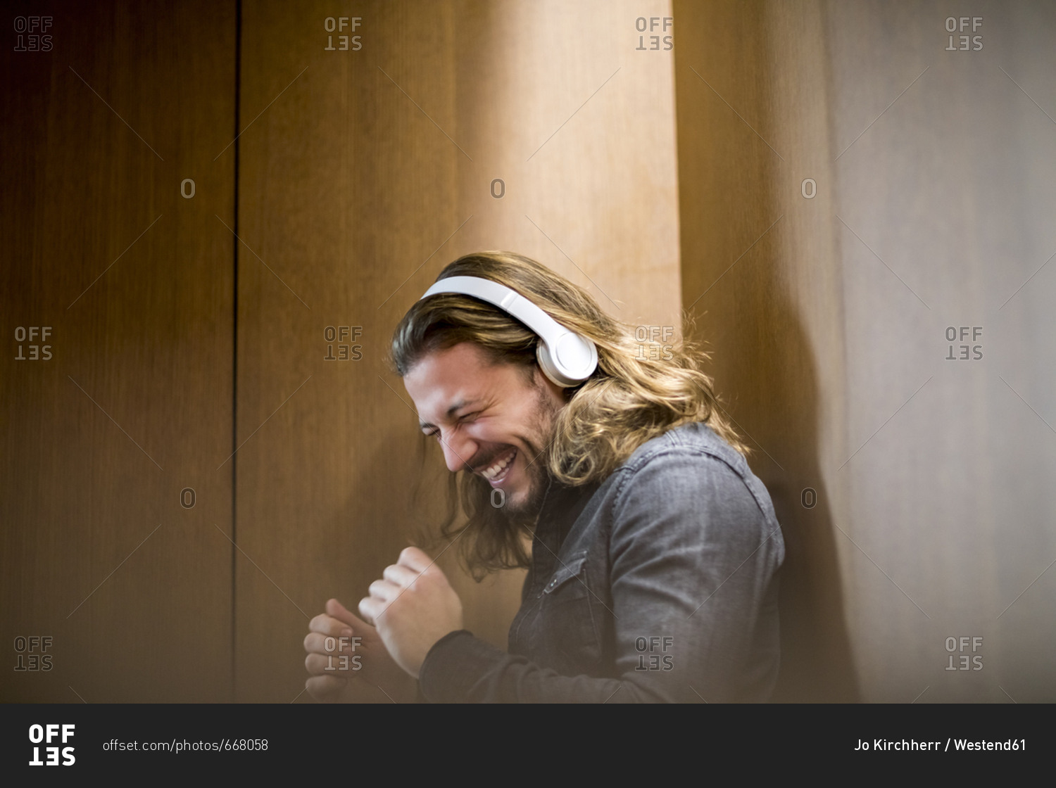 Portrait of excited man listening music with headphones