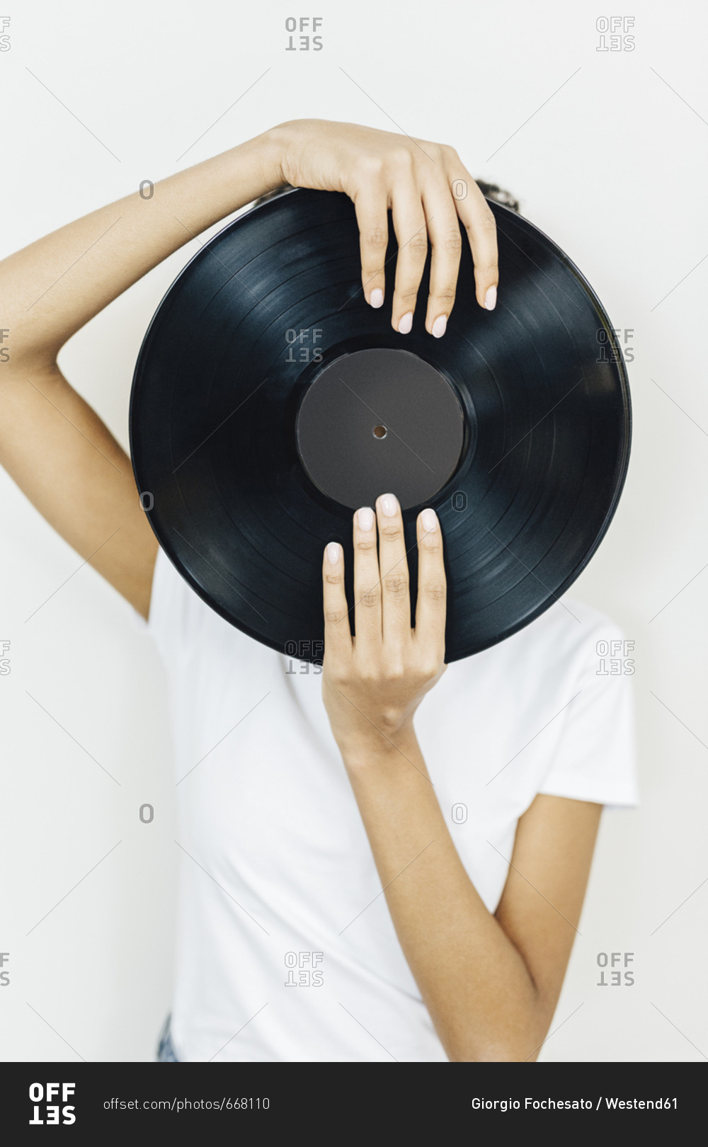 Young woman holding vinyl record in front of her face