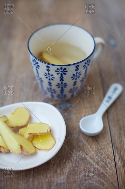 Ginger tea served with sliced raw ginger on plate