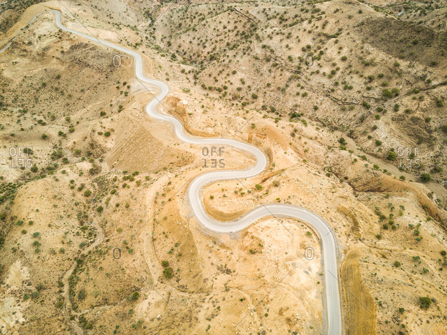 Aerial view of a serpentine empty road in the deserted landscapes of Ethiopia.