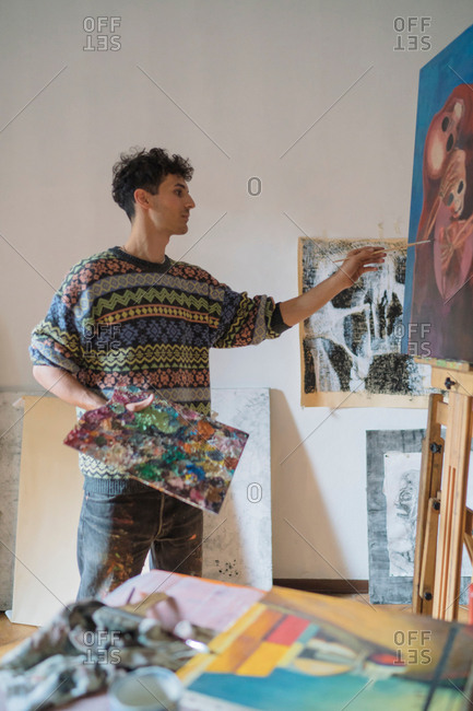 Male artist painting canvas in artists studio
