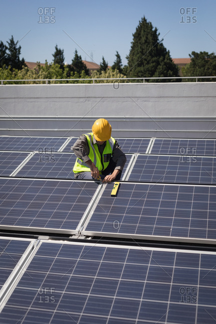 Male worker working on solar panels at solar station on a sunny day