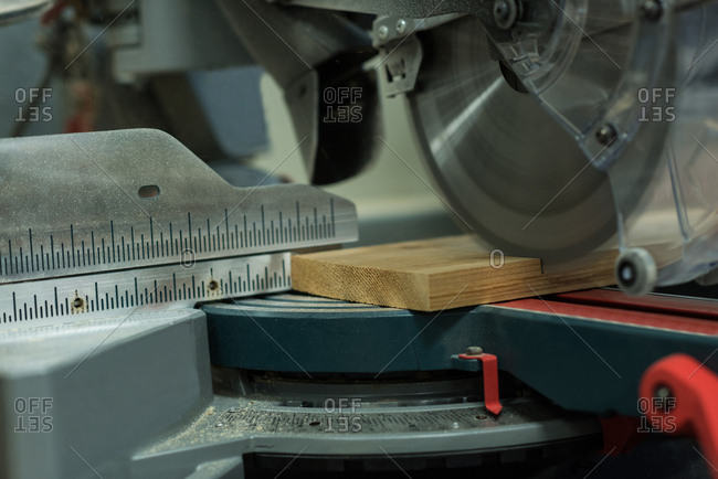 Grinder cutting machine cutting a piece of wood at workshop