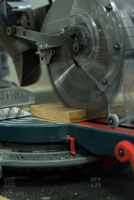Grinder cutting machine cutting a piece of wood at workshop